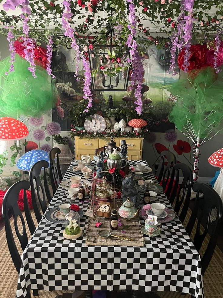 the table is set with black and white checkered cloths on it, surrounded by flowers