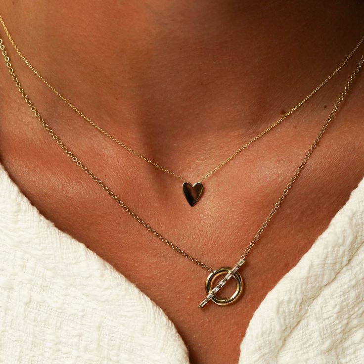 Simple and eternally classic, the DRD Heart Necklace is the perfect sentimental piece. Made of 14 karat gold and available in white, yellow, and rose, this heart necklace is also engravable. Fit up to three letters on the heart to keep your loved ones close to you at all times. The DRD Heart Necklace makes for an unforgettable and personal gift. Worn alone this delicate gold pendant necklace is romantic and chic. Layered with your other Dana Rebecca Designs pieces it adds a charming touch to your necklace stack. 14 Karat Gold Heart is 8.6mm in Length and 6.9mm in Width Adjustable Length: 16" or 18" Cable Chain Spring Ring Clasp To add a heart to your engraving, use "*" in the text box above. Please note engraving will add up to 10 days to delivery time For more products, we ask you to take Sterling Silver Heart Necklace With Delicate Yellow Gold Chain, Delicate Sterling Silver Heart Necklace In Yellow Gold, Yellow Gold Heart Necklace With Delicate Sterling Silver Chain, Minimalist Gold Plated Jewelry With Heart Charm, Minimalist Gold-plated Jewelry With Heart Charm, Everyday Gold Plated Double Heart Necklace, Everyday Yellow Gold Heart Necklace In Sterling Silver, Classic White Gold Charm Necklaces For Anniversary, Sterling Silver Necklace With Yellow Gold Heart Charm