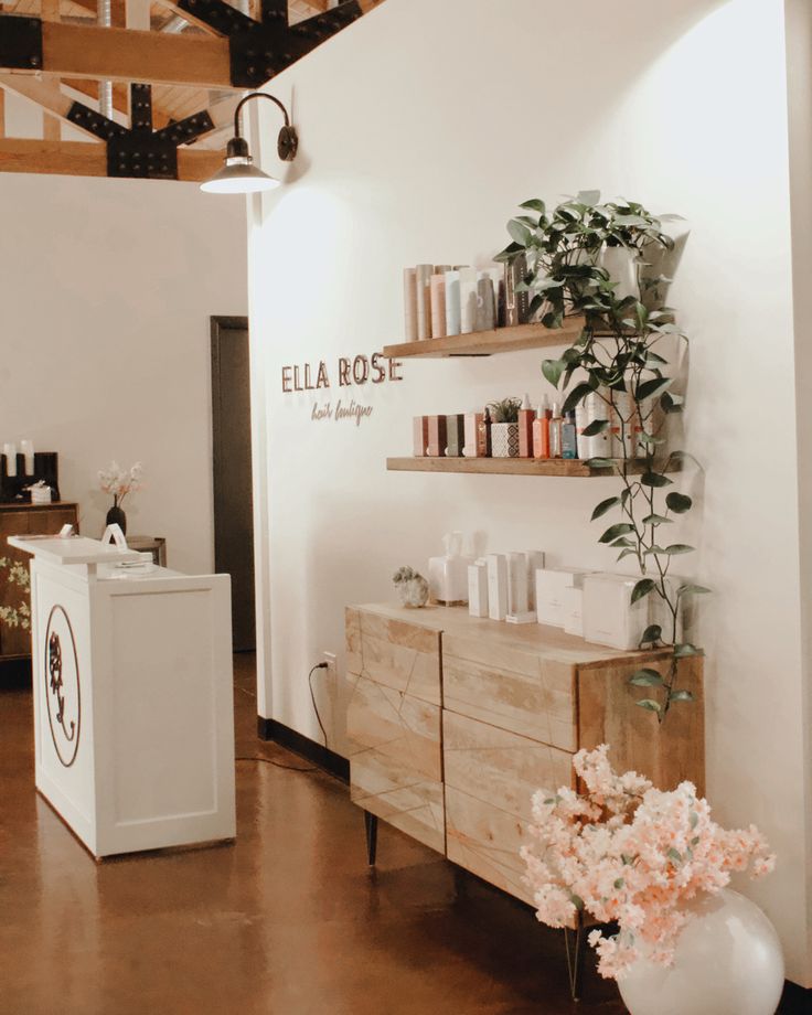 the inside of a hair salon with shelves and flowers in vases next to it