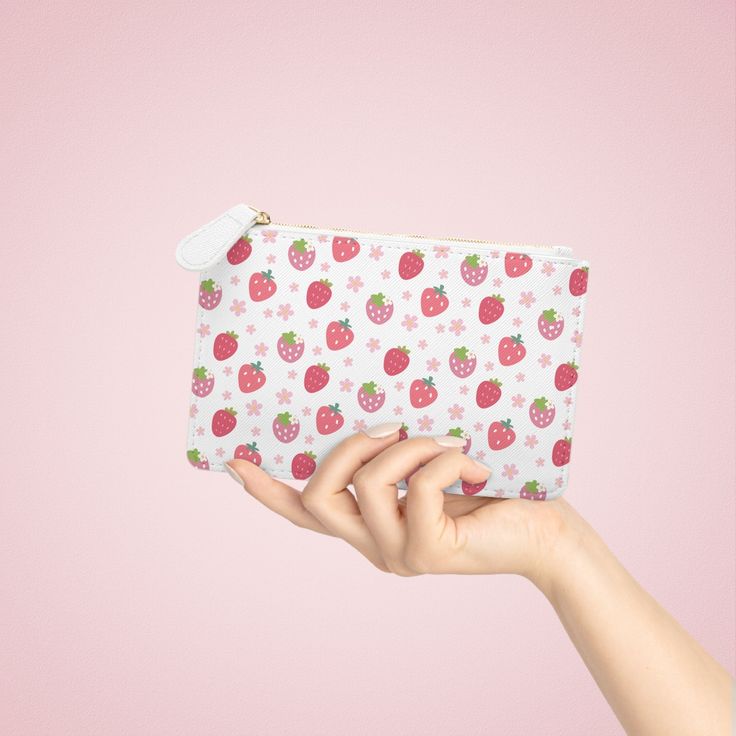 This compact Strawberries and Daisies Mini Clutch Bag is perfect for holding all your essentials on the go. Its cute and pretty design adds a touch of style to any outfit. With this handy bag, you can keep your belongings organized and easily accessible. Designed to be chic and highly portable, this mini clutch bag is made for anyone on the go. It can hold everyday essentials such as a phone, a wallet, and keys. It features a zip fastener and it is made of vegan, cruelty-free leather. .: Material: 100% polyurethane faux leather .: Double-sided print with Saffiano pattern finish.: One compartment for cash, cards, other small items.: Black lining.: Metal zipper closure 6.3” x 4” Width, in 6.30 Height, in 4.02 Depth, in 0.31 Cute White Bag With Zipper Pouch, Trendy Rectangular Bag With Strawberry Print, White Portable Cosmetic Bag Gift, Portable White Cosmetic Bag As Gift, Portable White Cosmetic Bag For Gift, Trendy White Zipper Pouch, White Kawaii Cosmetic Bag With Zipper Pouch, Cute White Rectangular Pouch, Trendy White Coin Purse For Everyday Use