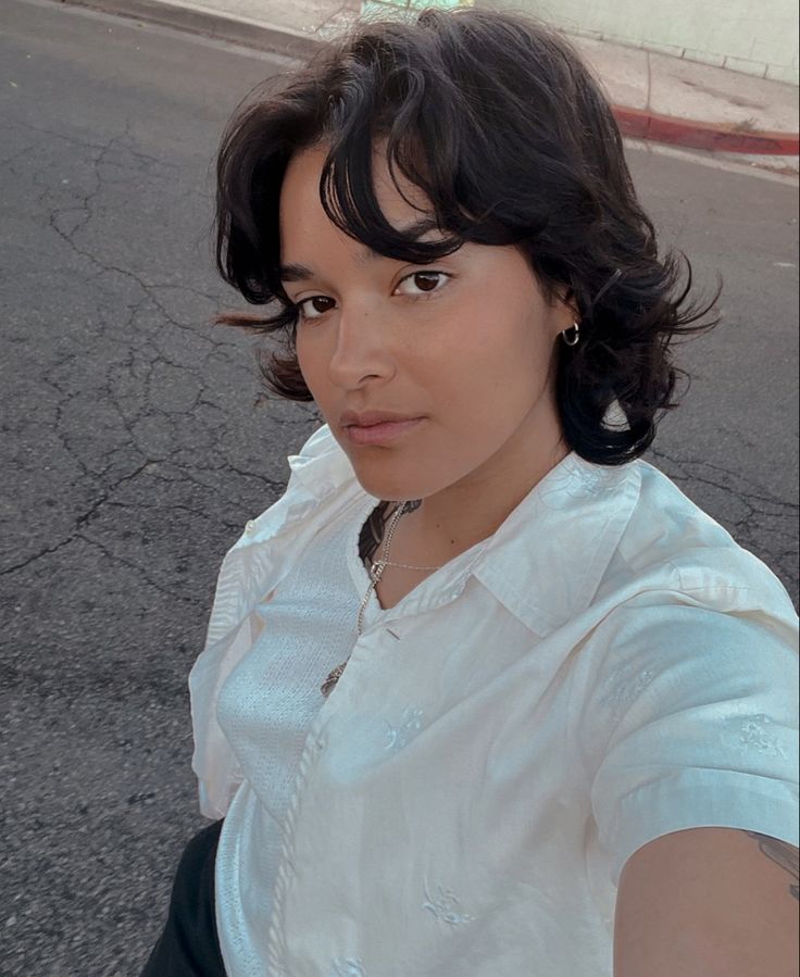 a woman is taking a selfie on the street with her cell phone up to her ear