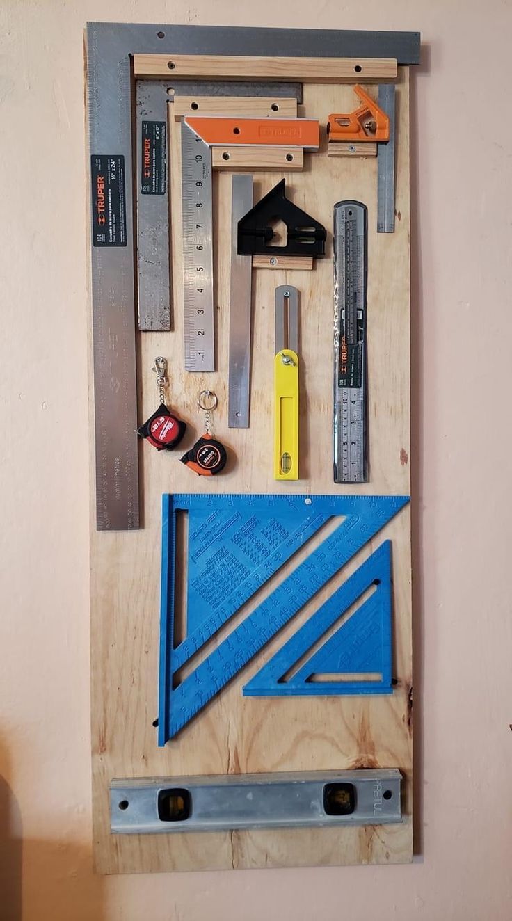 tools are arranged on top of a wooden board in the shape of a wall hanging