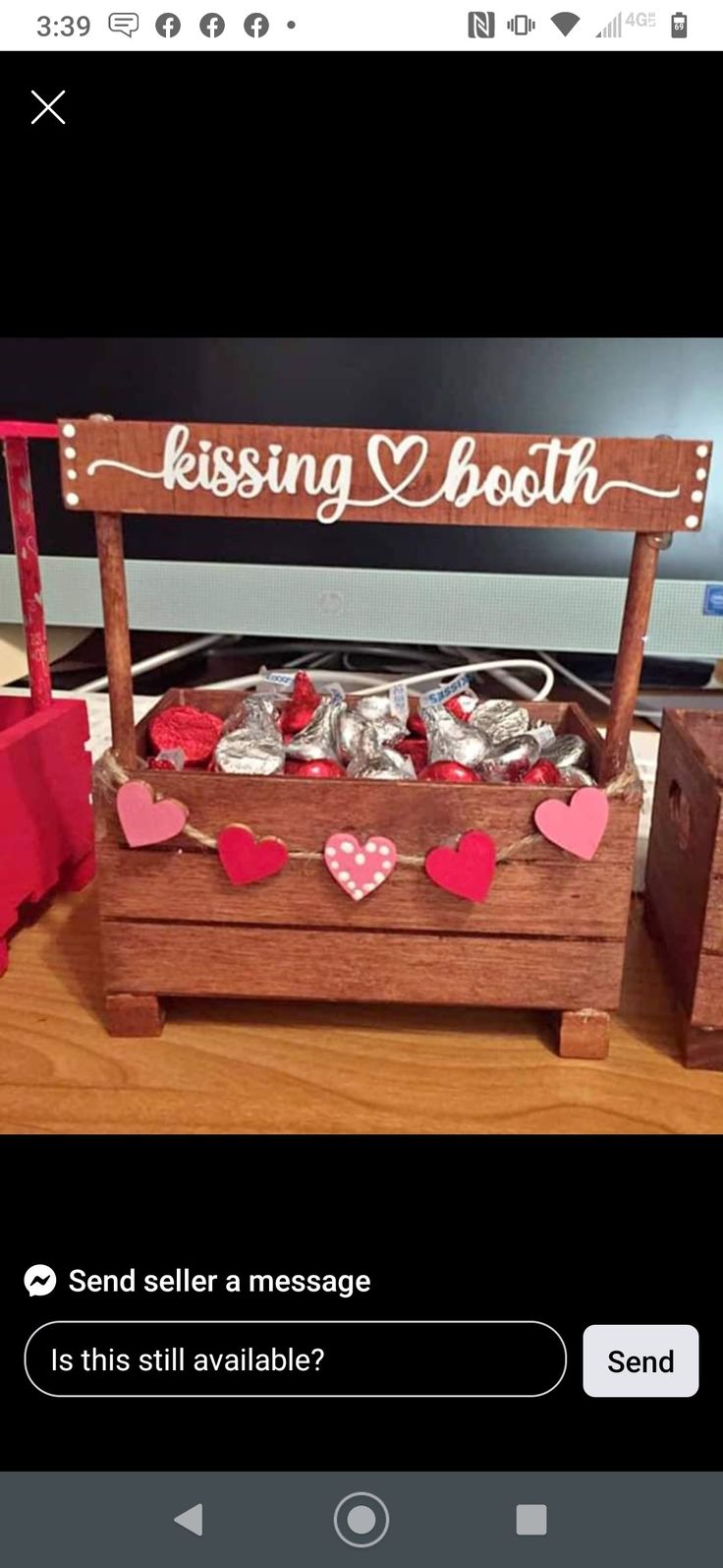 a wooden box filled with lots of hearts next to a sign that says kissing booth