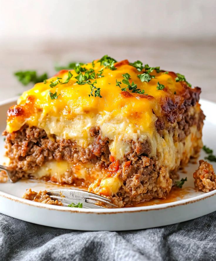 a slice of lasagna casserole on a white plate with a fork