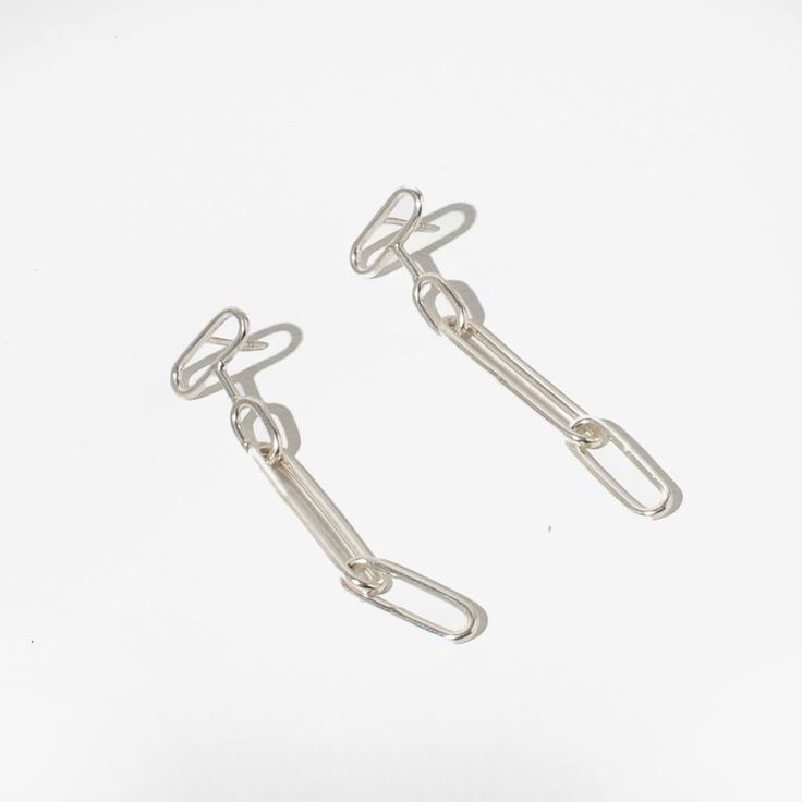 Elegant links form these intricate drop earrings. Lightweight and dazzling, they catch the light from every angle. The perfect accessory to elevate your wardrobe. While our designs are modern, our approach is based in capturing the ancient. We collaborate with master craftspeople to create each piece. Finish: Sterling Silver Length: 2.25" long Made entirely by hand, slight variations make each piece truly one of a kind Handcrafted in Nepal Link Shaped Pierced Earrings As Gift, Pierced Link Earrings For Gift, Minimalist Pendant Earrings, Minimalist Pendant Earrings For Pierced Ears, Minimalist Pendant Earrings For Everyday, Sterling Silver Link Earrings For Gifts, Elegant Dangle Jewelry With Hooks And Links, Silver Minimalist Pendant Earrings, Minimalist Silver Pendant Earrings