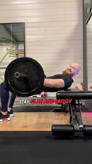 a man doing a bench press with a barbell on his back in a gym