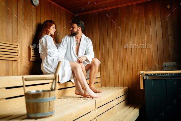 a man and woman sitting in a sauna - stock photo - images