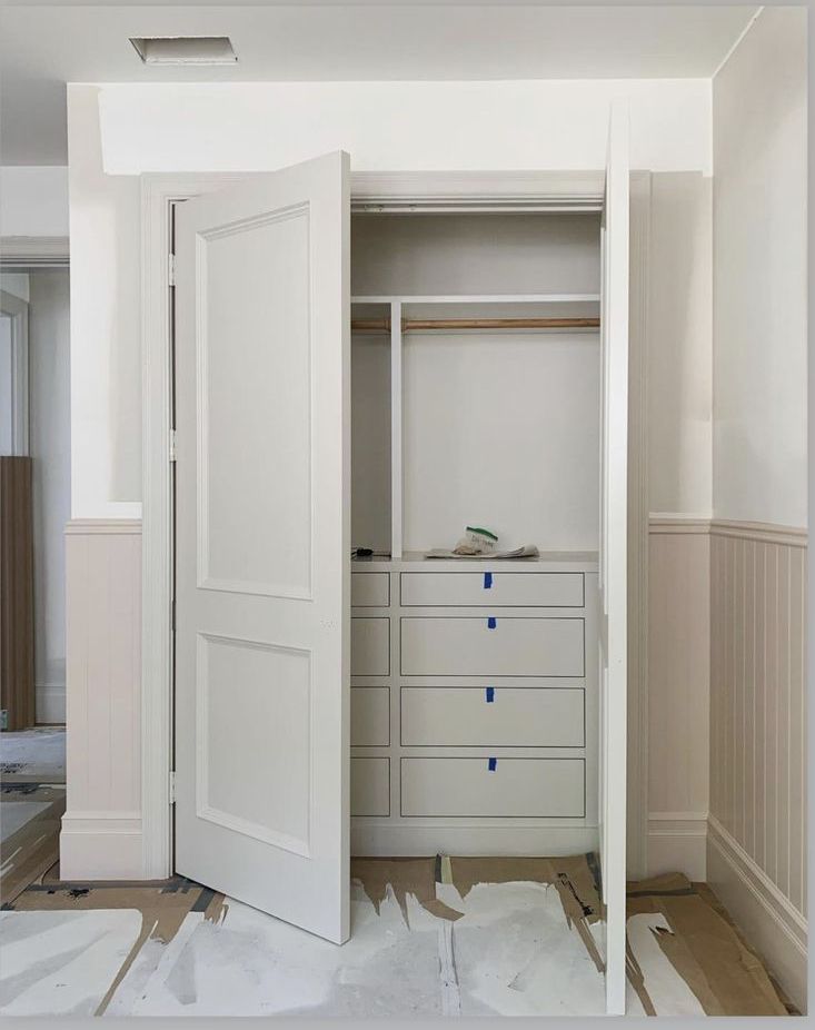 an empty closet with white doors and drawers on the floor in front of it is being remodeled