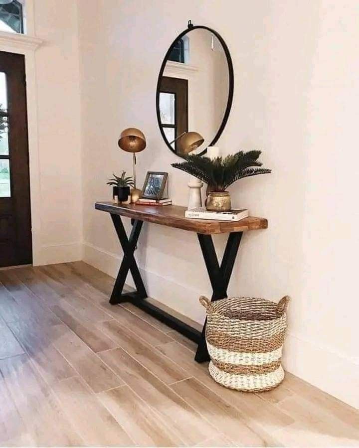 a wooden table topped with a mirror next to a plant