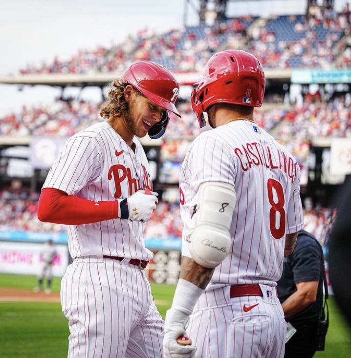 two baseball players standing next to each other on a field