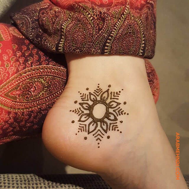 a woman's foot with a henna tattoo on it