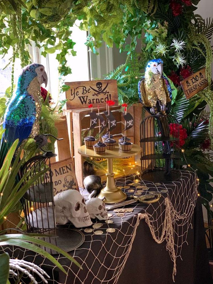 a table topped with lots of fake birds and other decorations on top of it's sides