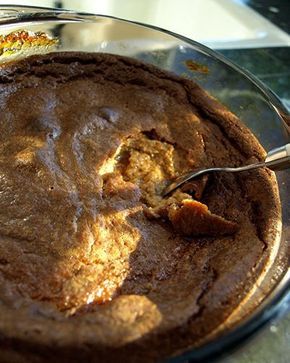 a close up of a cake on a plate with a spoon in it and a piece of bread sticking out of the top