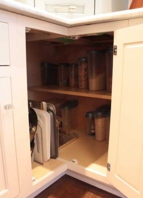 an open cabinet in a kitchen filled with appliances