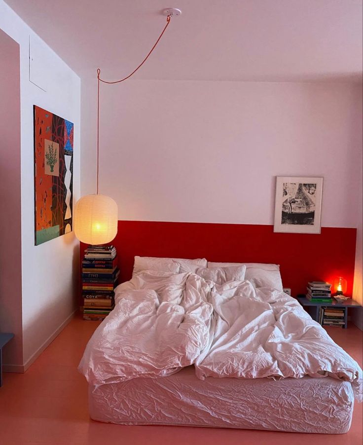 a bed sitting in the middle of a bedroom next to a red wall