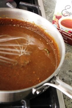 a pot filled with sauce and whisk on top of a stove next to a carton of eggnox