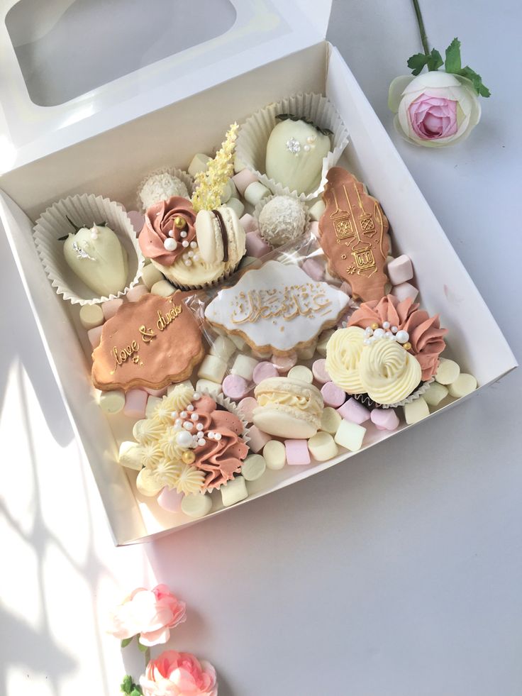 a white box filled with lots of different types of cookies on top of a table