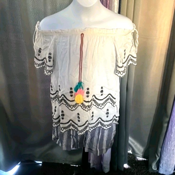 White With Black Embroidery And Colorful Balls At The Neck Cute White Vacation Shirt, White Short Sleeve Tops With Lace Trim, White Bohemian Shirt For Vacation, White Lace Trim Short Sleeve Tops, Casual White Blouse With Lace Trim, White Casual Blouse With Lace Trim, Cute White Blouse With Lace Trim, White Bohemian Summer Shirt, White Cotton Blouse For Vacation