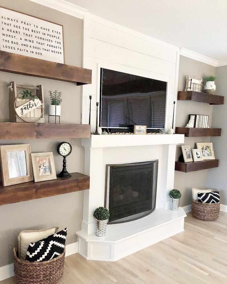 a living room filled with furniture and a flat screen tv mounted on a wall above a fire place