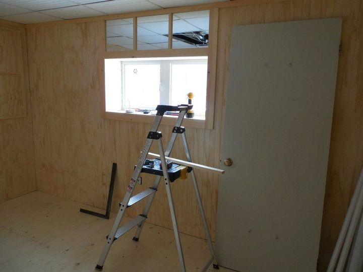 an unfinished room with a ladder and window