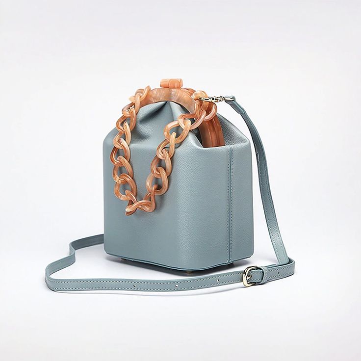 The Jade Mini Bucket Bag is crafted in smooth vegan leather featuring a contrasting faux tortoiseshell chain and frame in apricot color, kiss-lock closure, and a detachable shoulder strap. This timeless addition to your accessories edit can be carried by the top chain or as a crossbody with the detachable shoulder strap. Nude, White, Blue Sea, Leopard & Jade colors available. Vegan Leather Kiss-lock closure Imported Purse Aesthetic, Lady Dior Handbag, Expensive Bag, Apricot Color, Beaded Clutch Bag, Luxury Bags Collection, Mini Bucket Bag, Mini Bucket Bags, Girly Bags