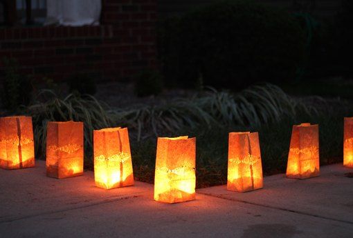 lighted paper bags sitting on the sidewalk at night