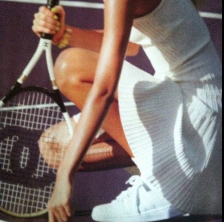 a woman holding a tennis racquet on top of a tennis court