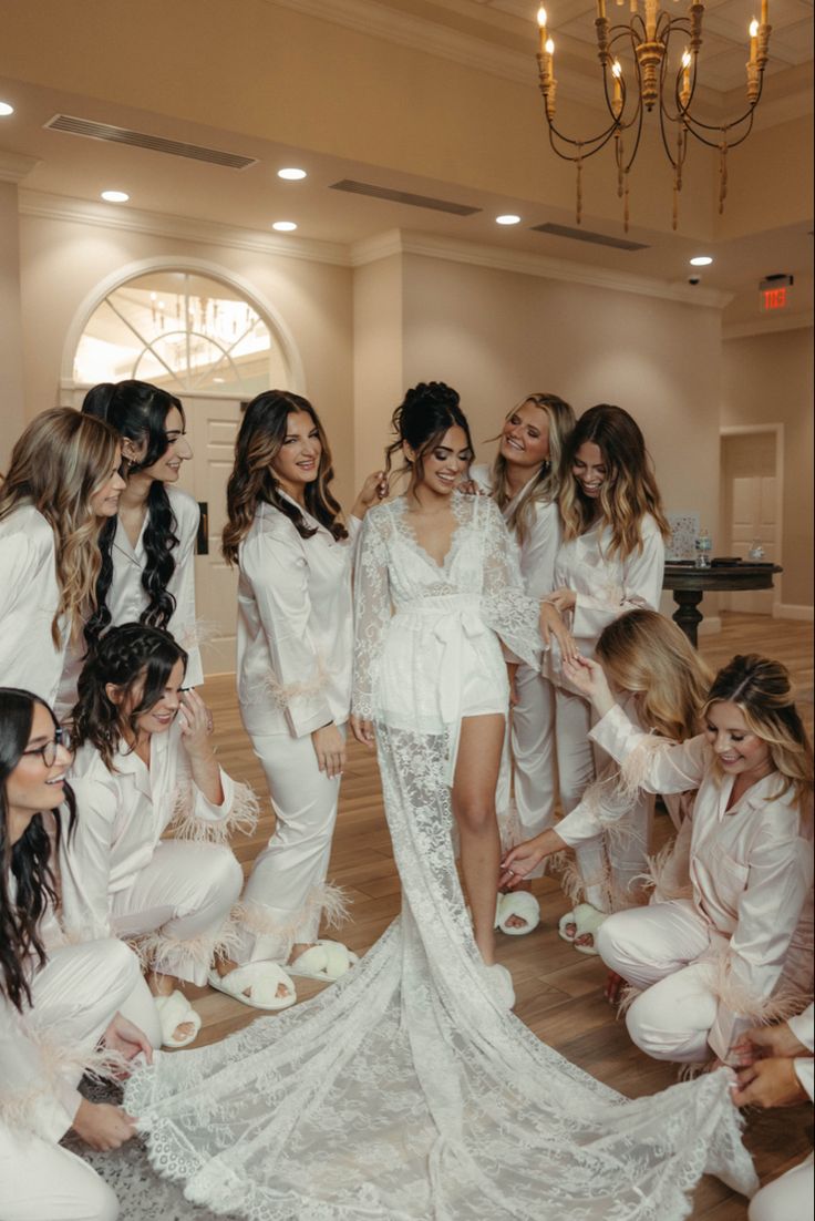 the bride and her bridal party pose for a photo in their white robes, all dressed