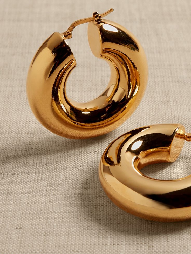 Perfectly-sized polished hoops with a plump profile and hollow core are made of bronze.  Timeless Classics: Luxury, everyday.  A showcase of time-honored craftsmanship and skilled Italian artisans, these are the pieces you'll reach for season after season, delighting in their exceptional versatility and endless appeal.  Hinged post backs.  12K-gold plated or silver-plated bronze.  Made in Italy.  Length: 1. 5" Wedding Stack, Hoop Earrings Aesthetic, Large Gold Earrings, Bold Statement Jewelry, Jewelry Photoshoot, Hoops Gold, Bronze Earrings, Bling Shoes, New England Style