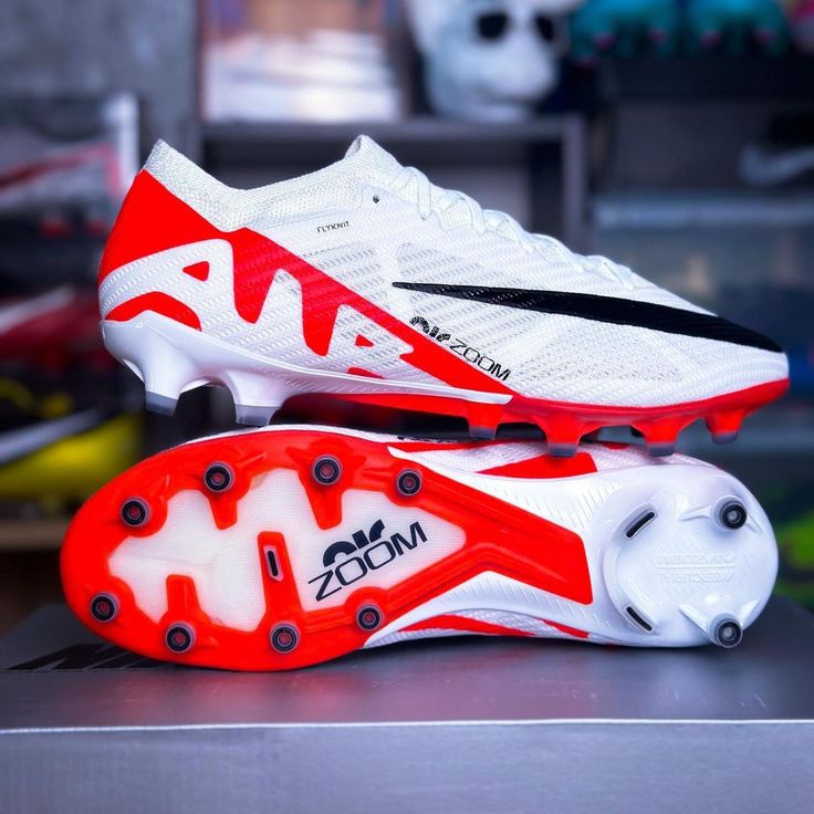 a pair of white and red soccer cleats sitting on top of a table