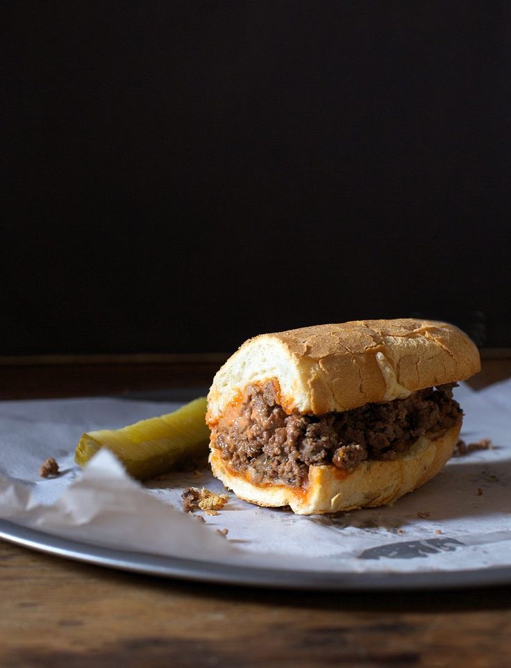 a sandwich with meat and pickle on a plate