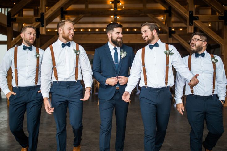 a group of men standing next to each other in front of a wooden structure with lights