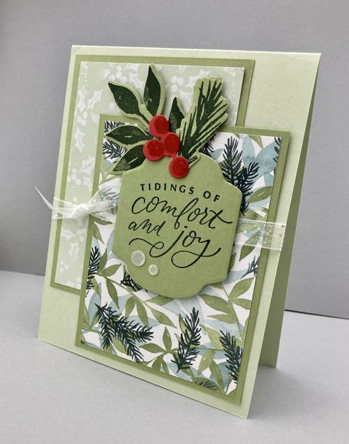 a christmas card with holly and mist on it, saying things of comfort and joy