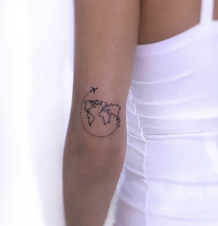 a woman's arm with a small world map tattoo on the left side of her arm