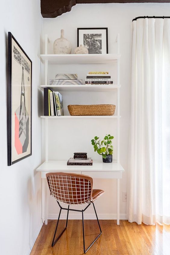 a white desk and chair in front of a window with bookshelves on it