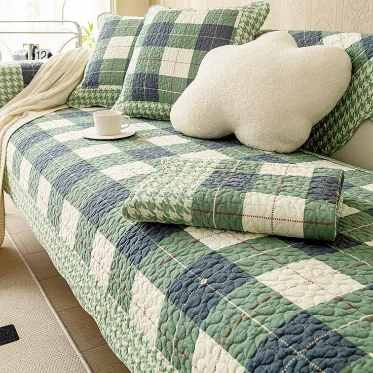 a green and white checkered bedspread with two pillows on top of it