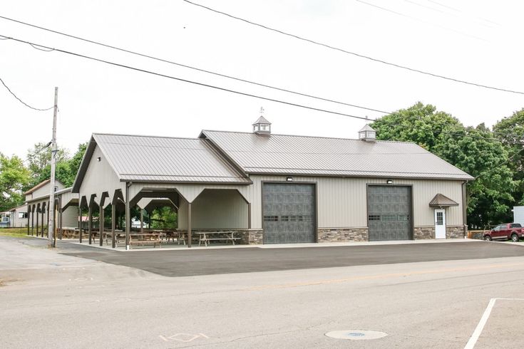 an empty parking lot in front of a building with two garages on each side