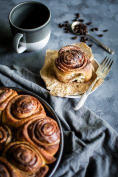 cinnamon rolls on a plate next to a cup of coffee