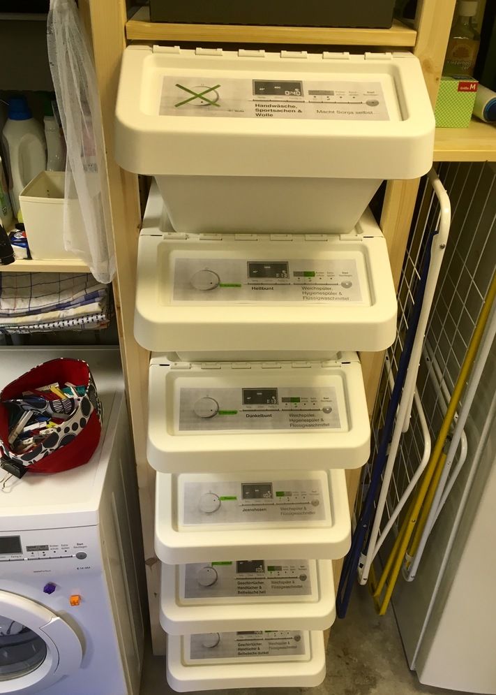 several plastic containers stacked on top of each other next to a washer and dryer