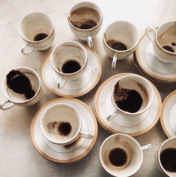 coffee cups and saucers filled with different types of coffee on a white counter top