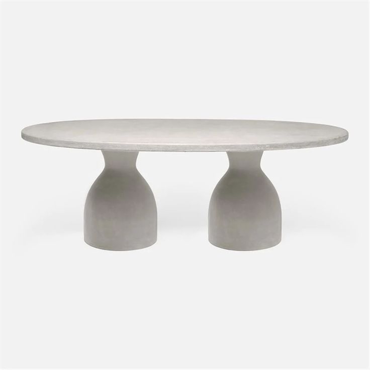 a white table with two grey vases on it's legs and an oval top