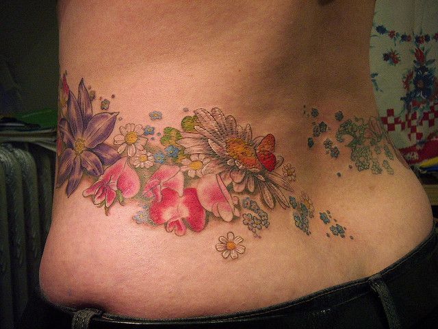 a woman's stomach with flowers and butterflies on it