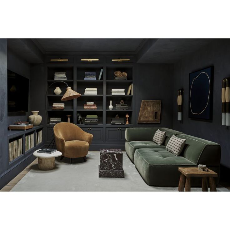 a living room filled with furniture and bookshelves next to a lamp on a wall