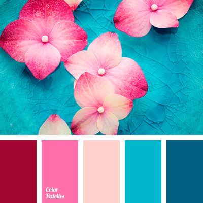 some pink flowers are on top of a teal blue plate with color swatches