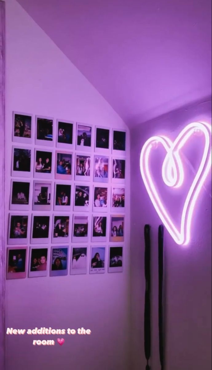 a purple neon heart hanging on the wall