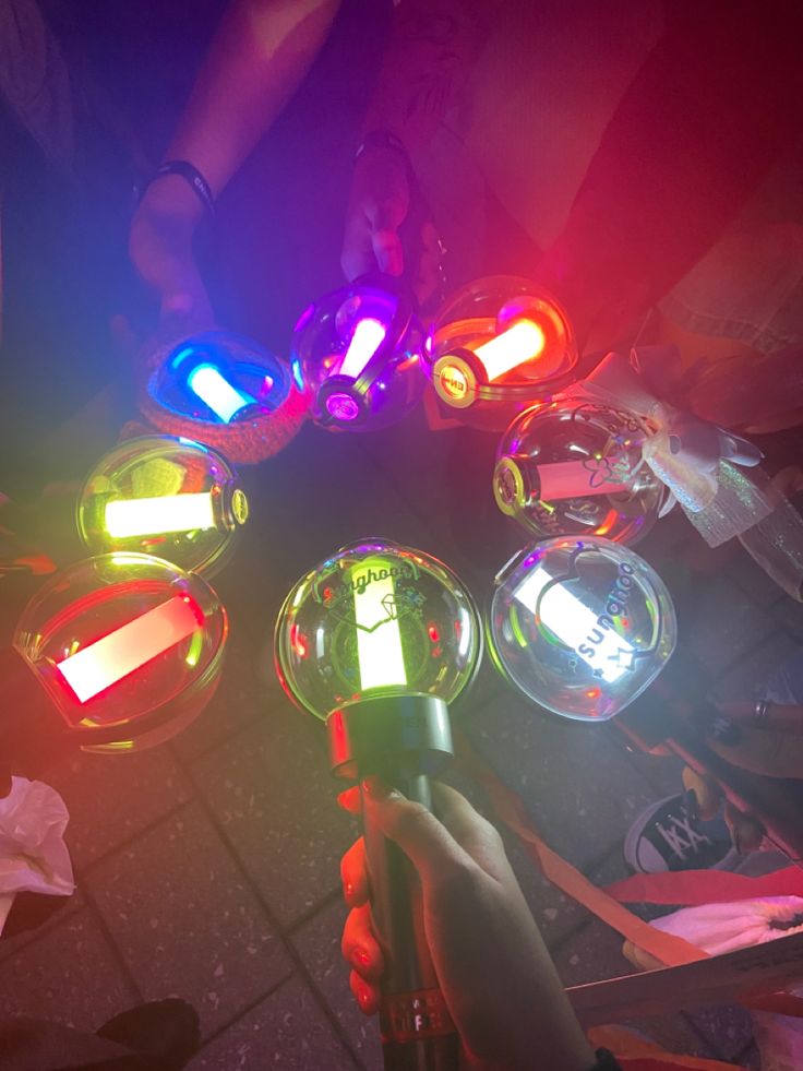 a group of people standing around each other with lights in the shape of bubbles on them