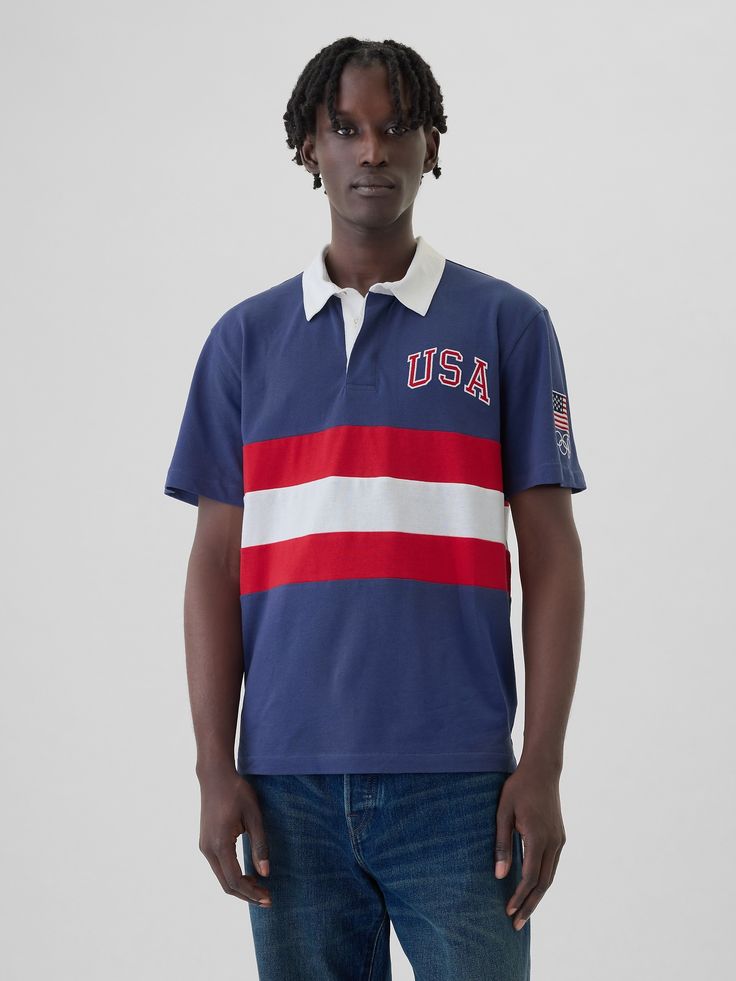 Soft cotton rugby polo shirt.  Polo collar, button placket.  Short sleeves.  Team USA graphics at chest and sleeve.  * Fit: Classic.  A straight & easy fit.  Hits at the hip.  Models are 6′1″–6′2″ 185 cm–188 cm) with a 31″ 79 cm) waist & 32–33″ 81 cm–84 cm) inseam & are wearing Gap Rugby Polo, Team Usa, Polo Collar, Button Placket, Rugby, White Stripe, Polo Ralph Lauren, Polo Shirt