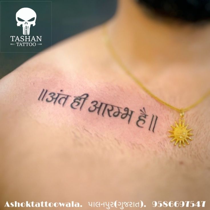 the back of a woman's chest with an inscription on it that reads, tatshan tattoo