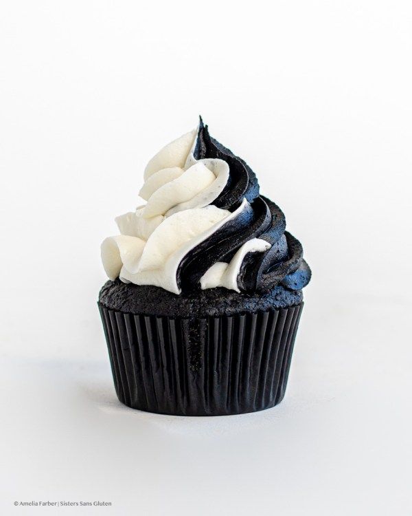 a cupcake with white frosting and black icing