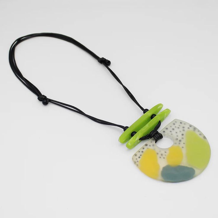 Make a statement with our vibrant Lime Mi Sol Statement Pendant! This artistically hand-painted pendant features a burst of lime and yellow with an accent of sky blue, bringing a touch of sunshine to any outfit. Crafted from durable resin on an adjustable wax cord, it's the perfect accessory for adding a pop of color to your look. Adjustable length: 16"-30"Pendant Dimensions: 3" x 3.5" Care Instructions:Remove jewelry when applying perfumes, creams, washing hands, etc. Do not store in direct sunlight. To restore color and shine, apply a drop of oil with a soft cloth. Hand Painted Pendant, Statement Pendant, Scarf Jewelry, Fashion Art, Jewelry Gifts, Color Pop, Statement Necklace, Polymer Clay, Wax